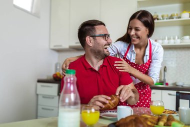 Neşeli genç çift mutfakta kahvaltı yapıyor.. 