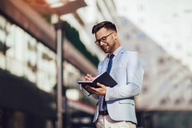 Office buildin dışarıda genç bir mutlu işadamı portresi