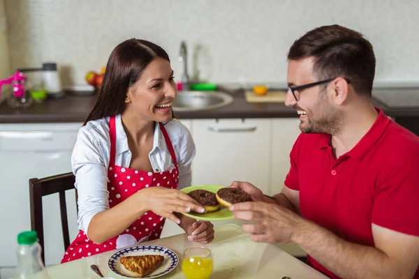 Веселая молодая пара завтракает на кухне дома . — стоковое фото