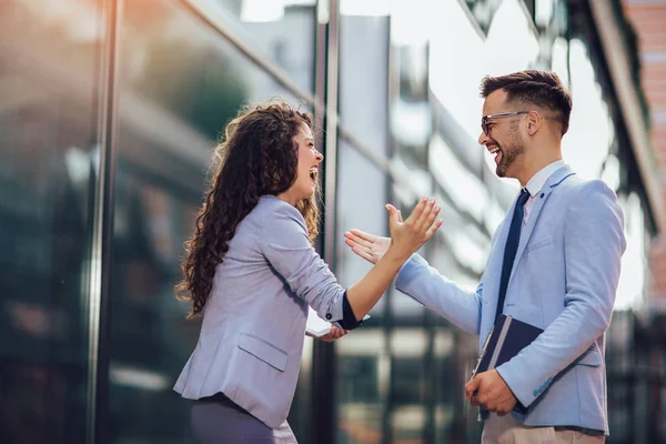 Lachende zaken collega's begroeten elkaar buitenshuis — Stockfoto