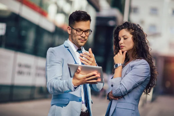 Hombre guapo y mujer hermosa como socios de negocios utilizando digi — Foto de Stock