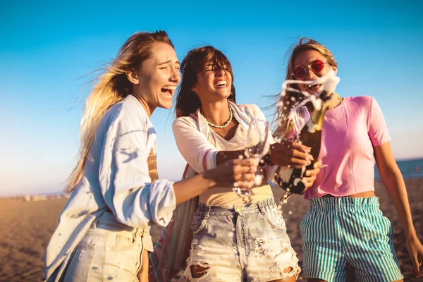 Vrienden die plezier hebben met champagne op het strand, — Stockfoto