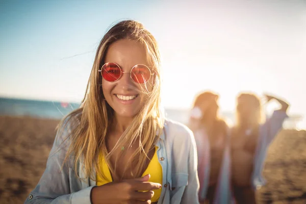 Feliz joven en la playa con sus amigos de fondo. G — Foto de Stock