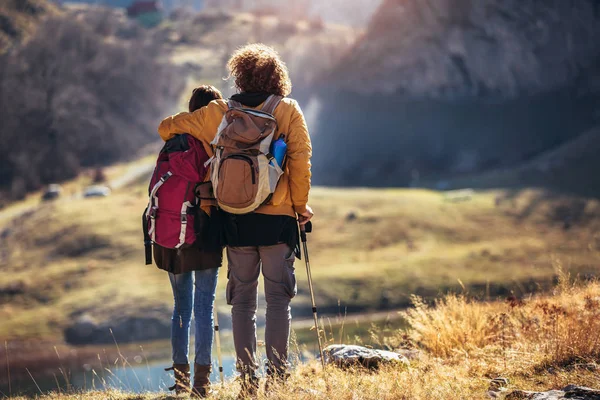 Coppia di escursionisti che camminano su una montagna in autunno . — Foto Stock