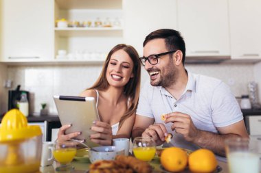 Mutlu çift evde birlikte kahvaltı zamanı zevk ve kullanarak 