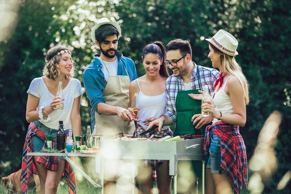 Jonge vrienden met plezier grillen vlees genieten van barbecuefeest. — Stockfoto