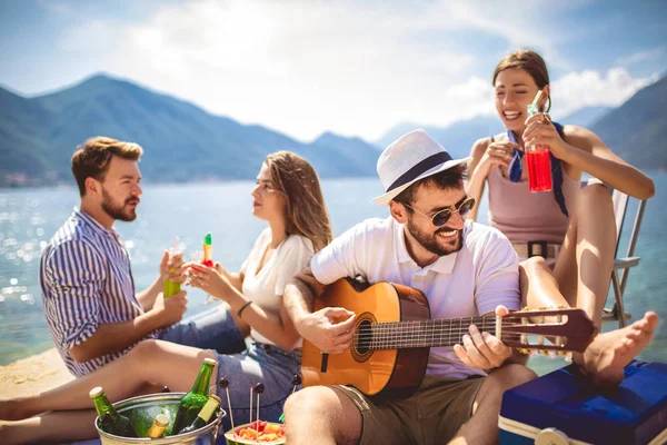 Unge mennesker har det gøy på sommerferie. Lykkelige venner drikker. – stockfoto