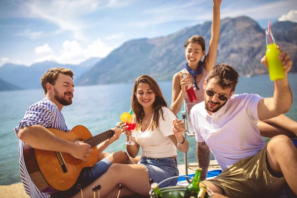 Unge mennesker har det gøy på sommerferie. Lykkelige venner drikker. – stockfoto