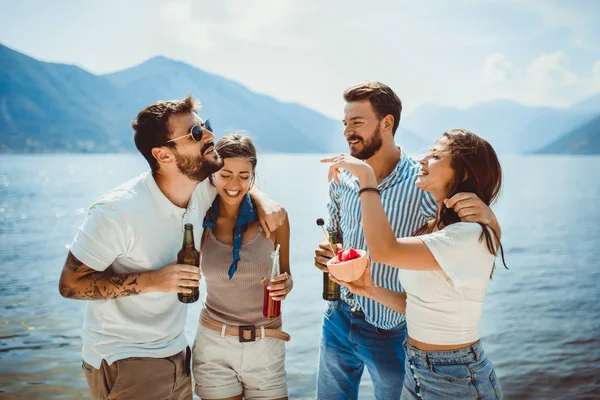 Друзі на пляжі п'ють коктейлі, розважаючись у літній відпустці — стокове фото