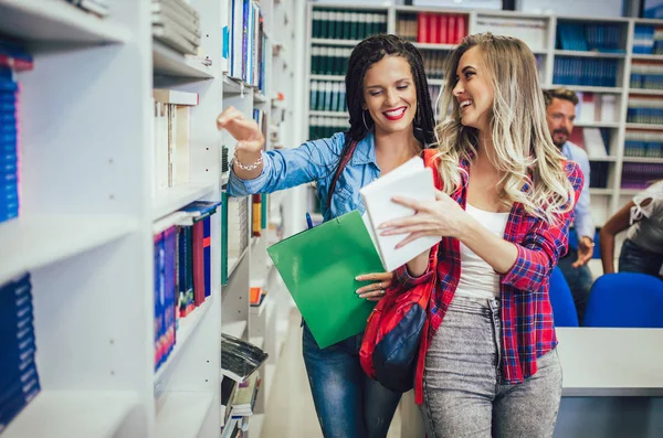 Группа студентов колледжа в библиотеке улыбается — стоковое фото