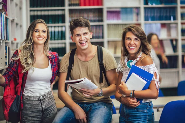 Gruppo di studenti universitari in biblioteca sorridenti — Foto Stock