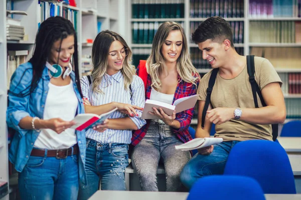 Groep van studenten in de bibliotheek glimlachen — Stockfoto