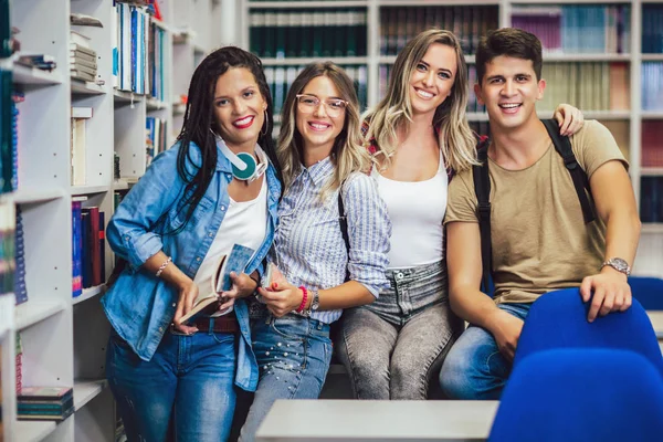 Группа студентов колледжа в библиотеке улыбается — стоковое фото