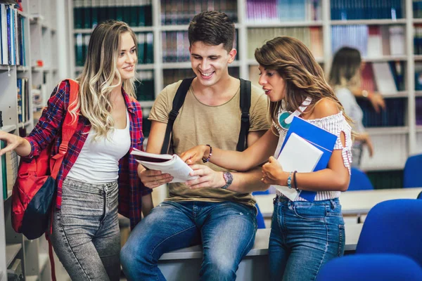 Groep van studenten in de bibliotheek glimlachen — Stockfoto