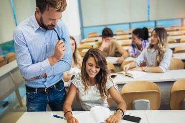 Genç öğrenciler üniversite lisi konusunda sınıfta profesör dinliyor