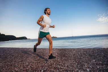 Sahilde koşan adam. Worki dışında erkek koşucu eğitimi