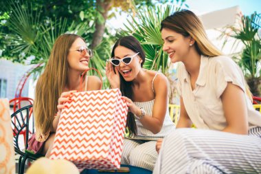 Bir kafede alışveriş yapan üç genç kadın.