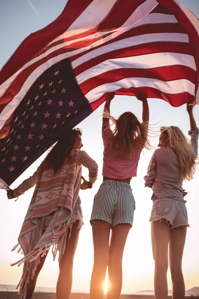 Junge Freunde mit amerikanischer Flagge am Strand — Stockfoto