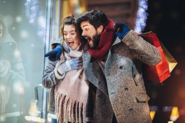 Walki sırasında Noel ışıkları arka plan üzerinde hediye çantası ile Çift