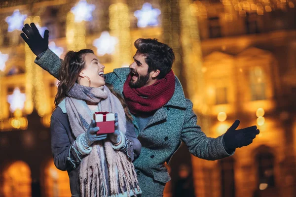 Ungt par i centrum med Holiday ' s Brights i bakgr — Stockfoto