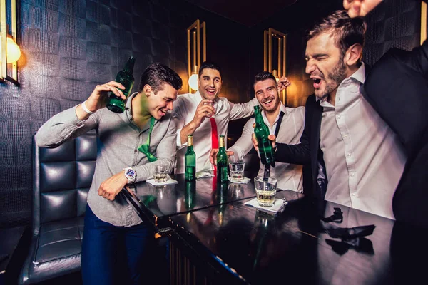 Groupe de jeunes hommes trinquant dans une boîte de nuit — Photo