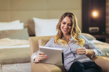 Dijital masa kullanarak otel odasında genç çekici iş kadını