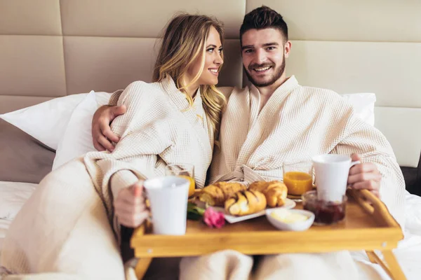Young happy couple having breakfast in luxury hotel room — Stock Photo, Image