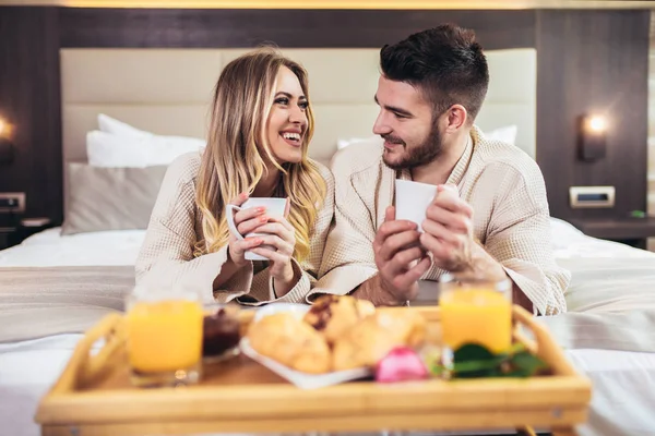 Giovane coppia felice fare colazione in camera d'albergo di lusso . — Foto Stock