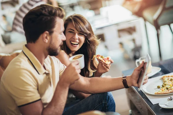 Skutt av et ungt lykkelig par som spiser pizza på en restaurant – stockfoto