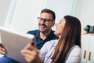 Genç çift li bir tablet te medya içeriği online izliyor