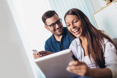 Tablet pc bilgisayar ve kredi veya banka ile Gülümseyen mutlu çift 