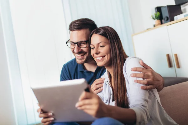 Young couple watching media content online in a tablet in the li — Stock Photo, Image