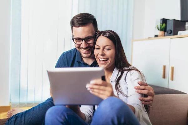 Young couple watching media content online in a tablet in the li — Stock Photo, Image