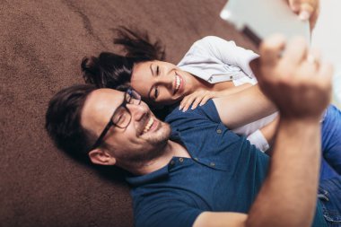 Genç çift li bir tablet te medya içeriği online izliyor