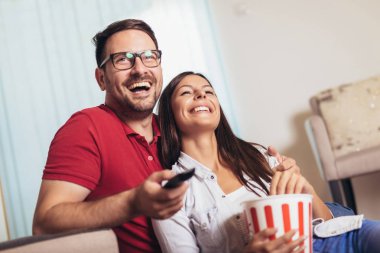 Aşık çift bir oturma odası kanepede oturan, Tv ve ea izlerken