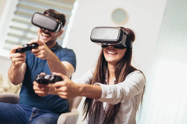 Young happy couple playing video games virtual reality glasses.