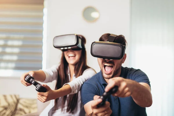 Unga lyckliga par som spelar video spel Virtual Reality glasögon. — Stockfoto