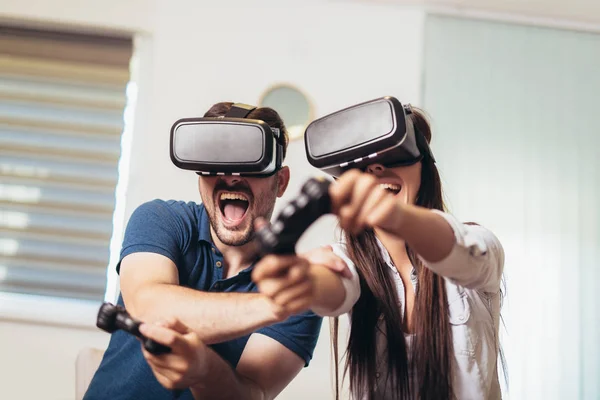 Unga lyckliga par som spelar video spel Virtual Reality glasögon. — Stockfoto