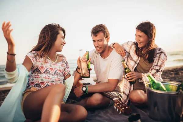 Lykkelige venner som fester på stranden med drinker – stockfoto