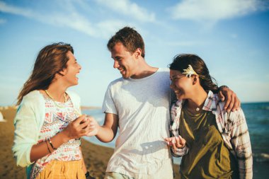 Sahilde yürüyüş eden genç arkadaşlar. Gençler arıyor h