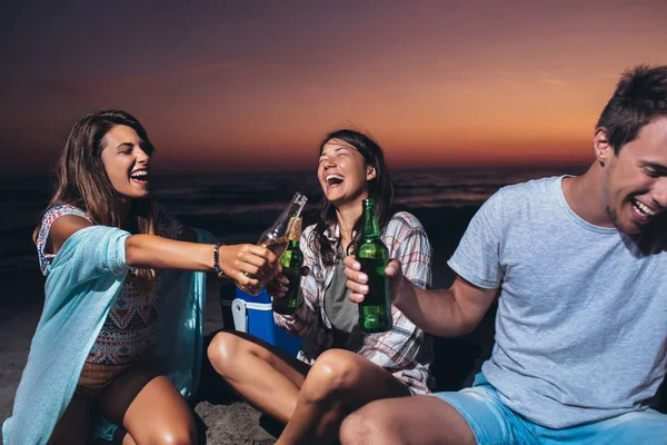 Lykkelige venner som fester på stranden med drinker – stockfoto