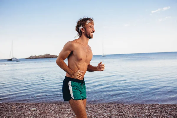 Un joven entrenando en la playa por la mañana. Joven por la mañana — Foto de Stock