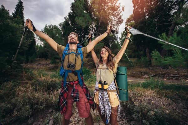 Young, beautiful couple holding rising hands in forest. — Stock Photo, Image