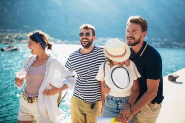 Bir grup arkadaş tatilde deniz kenarında eğleniyorlar.