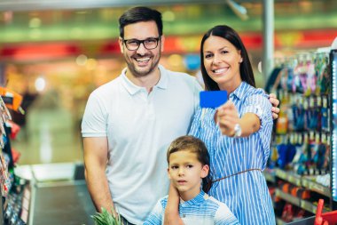 Çocuk ve alışveriş sepeti ile mutlu aile bakkal yiyecek satın alma