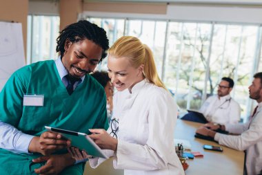 Tıbbi ekip oturma ve ofiste masada tartışıyor.
