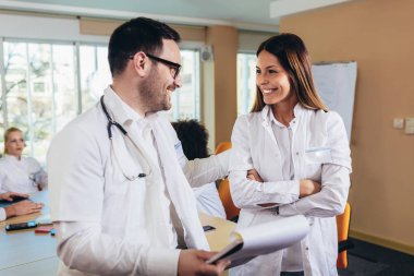 Tıbbi ekip oturma ve ofiste masada tartışıyor.