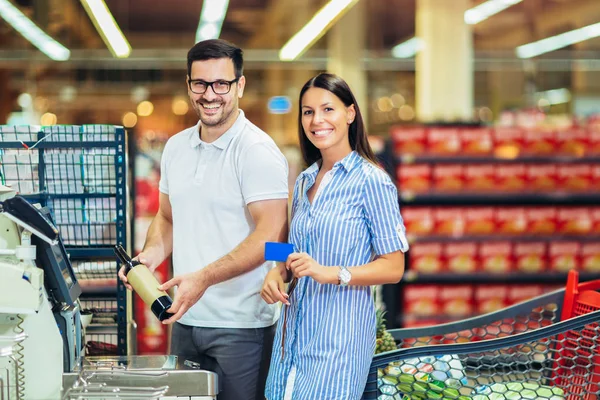 Пара с банковской картой, покупающая еду в продуктовом магазине или супермаркете — стоковое фото