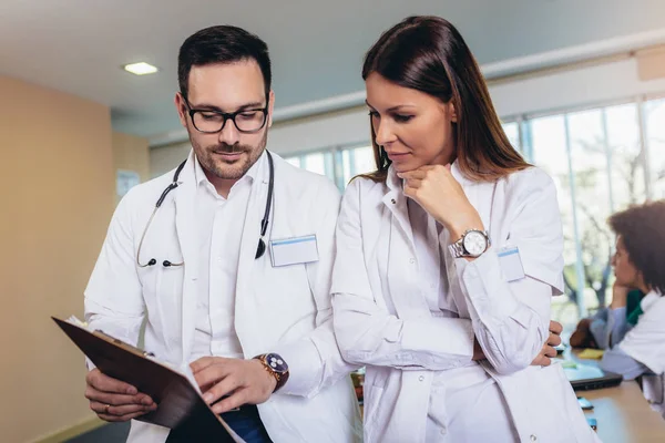 Ärzteteam sitzt am Tisch im Büro und diskutiert, — Stockfoto