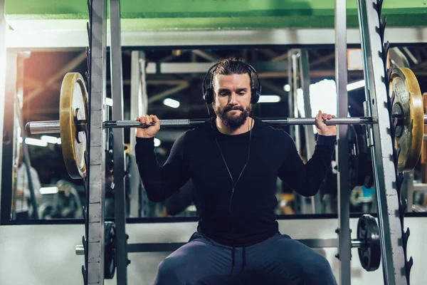 Joven hombre guapo en ropa deportiva haciendo ejercicio en el gimnasio —  Fotos de Stock